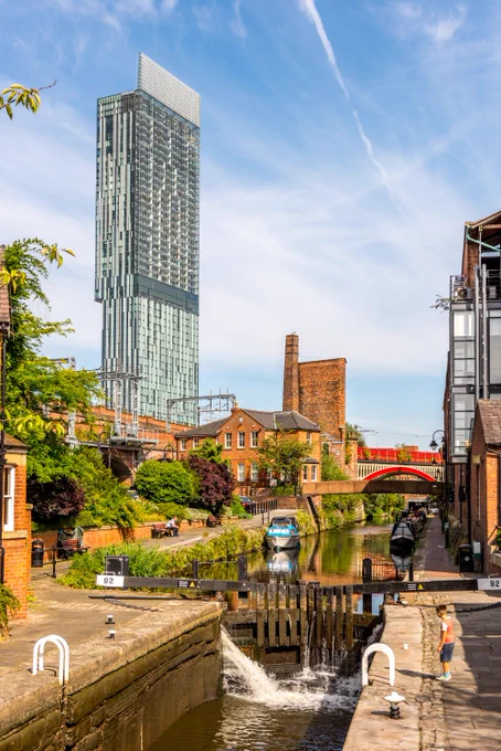 View of the canal path in Castlefield with historic industrial buildings and Beetham Tower