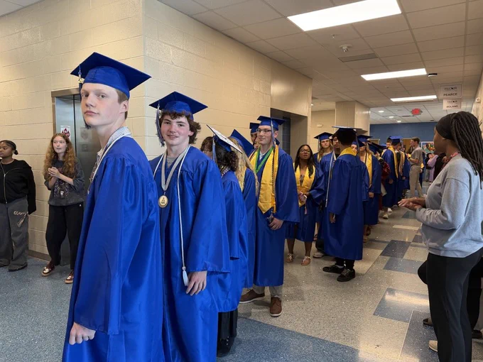 A group of seniors stand together as they wait to begin their senior walk through through the halls of the middle school they once attended.