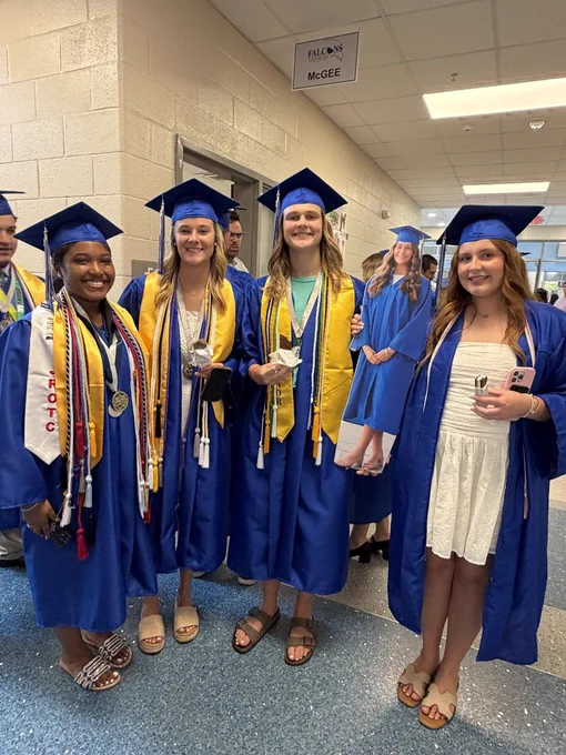 A group of seniors stand together smiling at the camera and holding ice cream in their hands after the senior walk through.