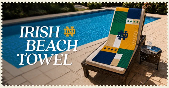 A lounge chair by a pool features a colorful beach towel with the Notre Dame logo and shamrocks. A book is placed nearby. Text reads, "Irish Beach Towel.