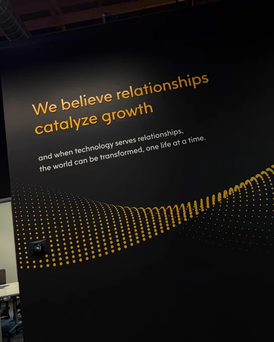 A motivational quote on a dark wall emphasizes the importance of relationships in driving growth. Yellow dotted patterns add a modern touch.