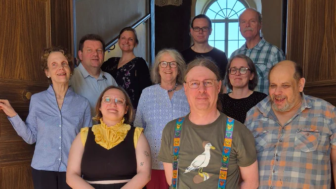 Eine Gruppe von Menschen steht auf einer Treppe und schaut in die Kamera. Es sind Ehrenamtliche der Wikipedia, Mitarbeitende der Friedenstein Stiftung und der Forschungsbibliothek Gotha.