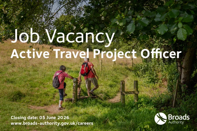 A promotional image for a job vacancy at the Broads Authority for an “Active Travel Project Officer.” The background shows two people walking through a grassy countryside path under large leafy trees, carrying backpacks. Large white text reads “Job Vacancy Active Travel Project Officer.” Smaller text at the bottom states “Closing date: 05 June 2026” and “www.broads-authority.gov.uk/careers.” The Broads Authority logo appears in the lower right corner. 