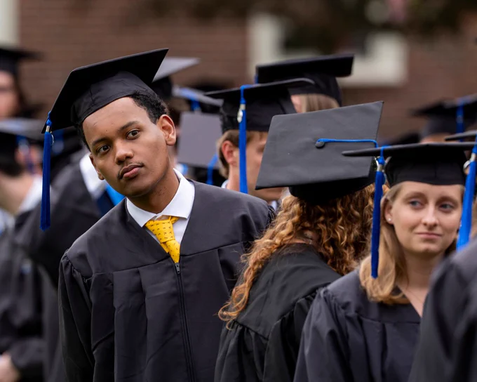 a group of graduates in robes standing in line