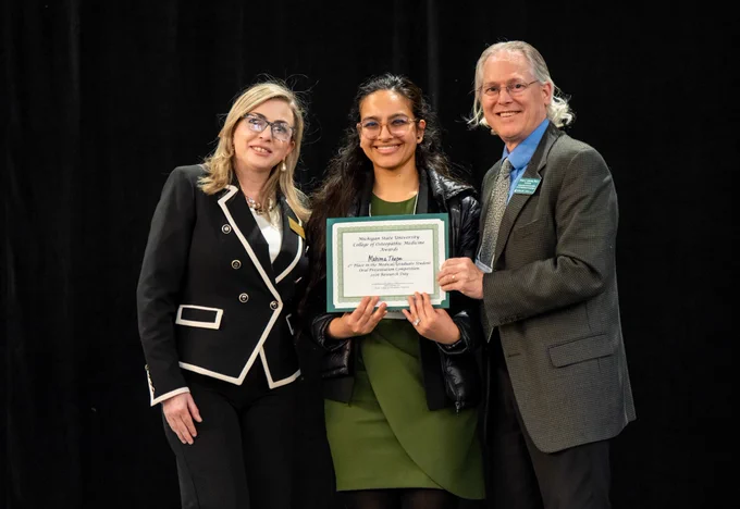 Mahima Thapa stands with members of the MSU COM faculty as she receives her award for her oral presentation. 