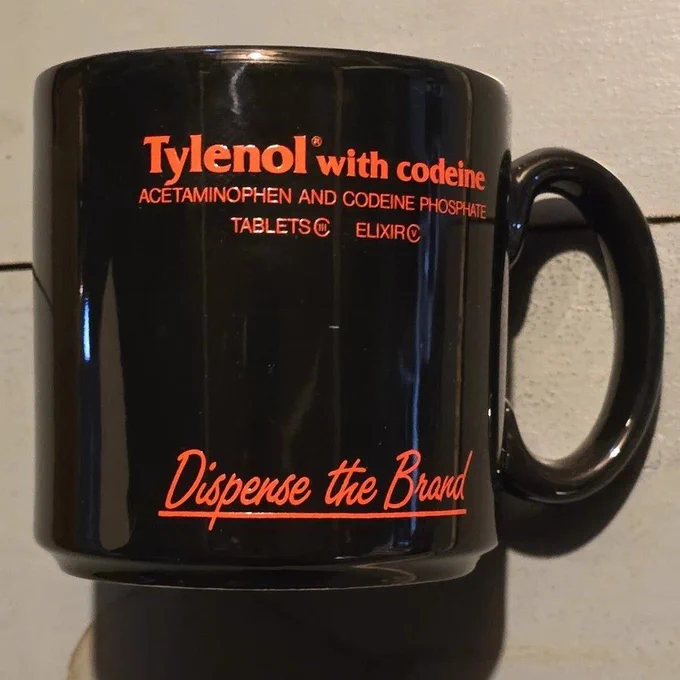 Black pharmaceutical mug with red print promoting Tylenol with codeine. 