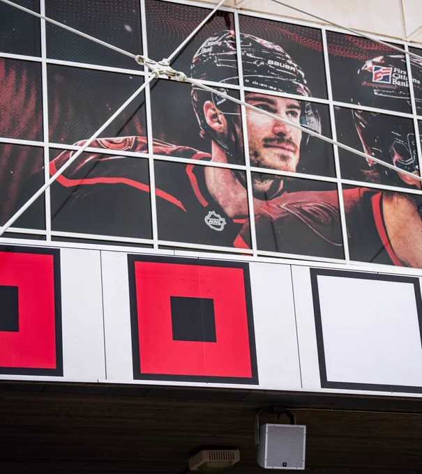 Photo of the tenth warning flag below Andrei Svechnikov's photo outside the Lenovo Center 