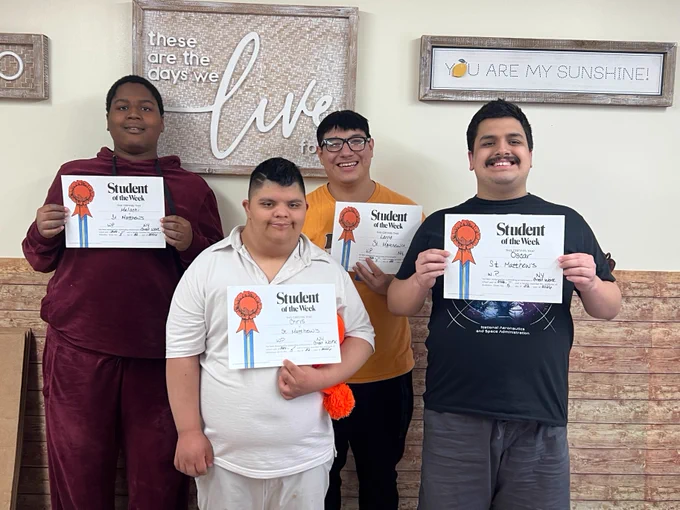 Four boys hold up Student of the Week certificates