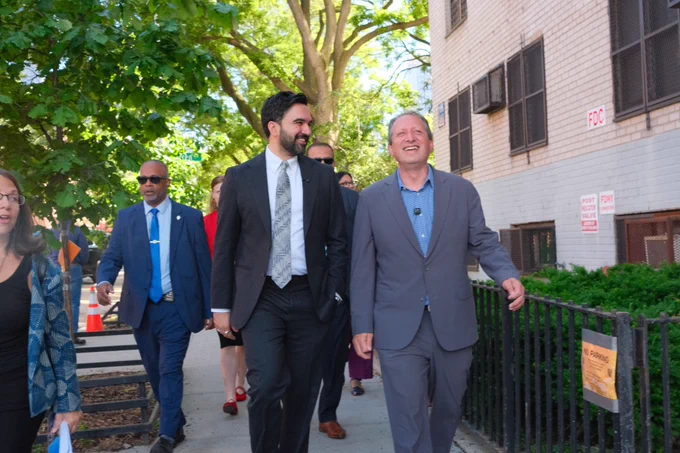 Laughing and walking alongside Mayor Mamdani.