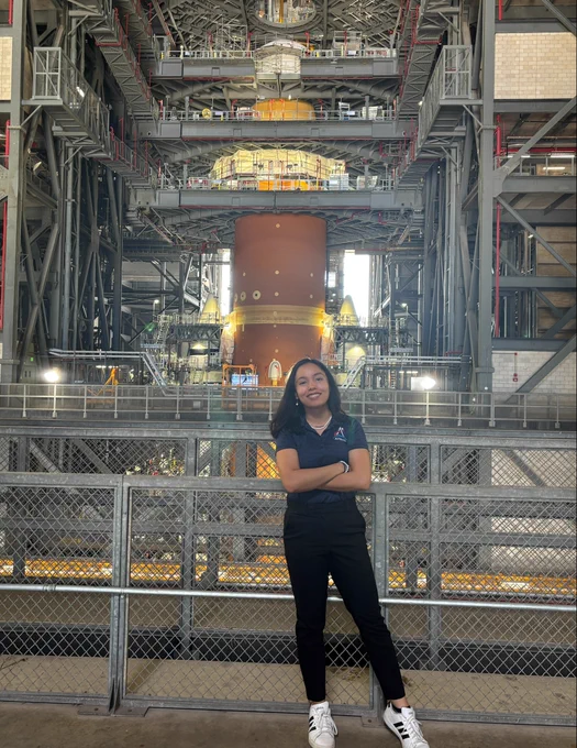 Hannah standing inside a NASA facility in front of the Artemis II SLS Rocket