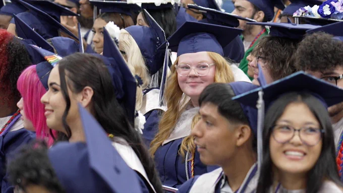 Graduates smile.