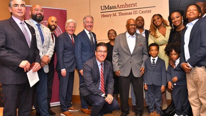 Former Chair of the UMass Board of Trustees and Urban League of Springfield President Henry M. Thomas III standing with his family, and UMass President Marty Meehan, and UMass Amherst Chancellor Javier Reyes in the Henry M. Thomas III Center.