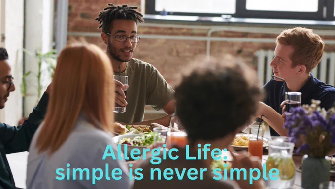 Five friends share a meal at a restaurant. Teal text says: "Allergic Life: simple is never simple."  Image by fauxels on pexels.