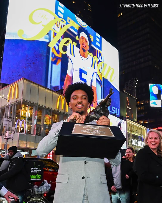 Photo. Jayden Daniels holding the Heisman trophy. 