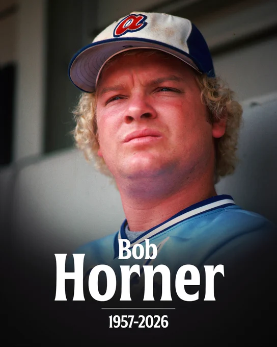Bob Horner
1957-2026
Pictured: Bob Horner sits in the dugout and looks out towards the field. He wears a blue Braves uniform and white and blue cap.