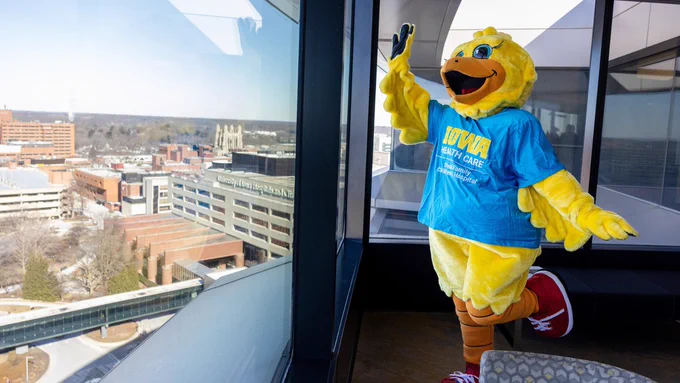 Perky waves toward Kinnick Stadium from Level 12 at the Stead Family Children's Hospital. Created in 2002, the mascot was designed to be a friendlier face for young patients.