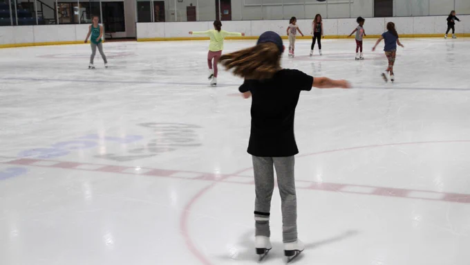 Young girls learn to skate at the ice rink.