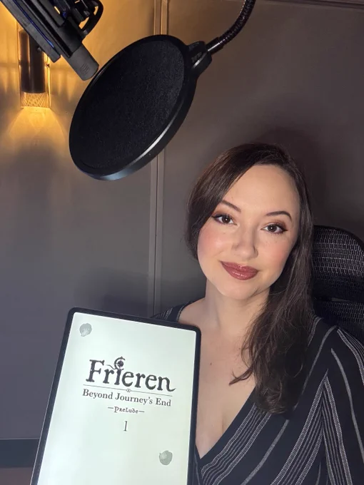 Narrator Mallorie Rodak, in a recording booth, holding a digital version of Frieren: Beyond Journey's End -Prelude- Volume 1