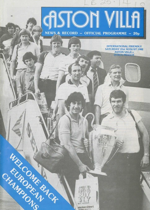 Front cover of a football programme. Caption in the top left reads – Aston Villa News & Record. Photograph of a group of male figures descending from the staircase of an aeroplane. The two male figures at the bottom of the steps are holding the European Cup. Caption in the bottom left reads  - Welcome Back European Champions. 