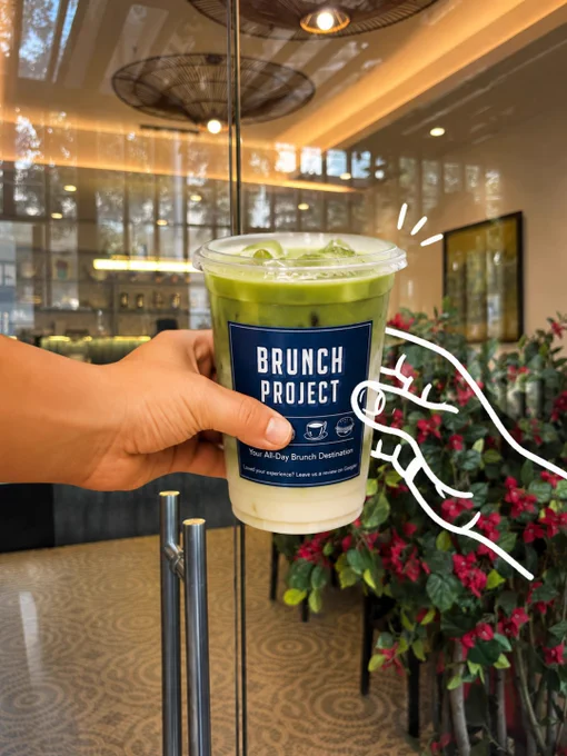 Aesthetic café and brunch lifestyle visuals from The Brunch Project in Koramangala, Bangalore. The first image shows a creamy iced green matcha latte held in front of the café entrance with warm ambient interiors, floral décor, and playful white doodle hand illustrations creating a fun editorial café aesthetic. The second image features a cozy marble-top café table with minimalist interiors, a decorative lemon plant, and a whimsical hand-drawn character illustration holding a coffee cup, adding an artistic and relaxed vibe. The third image captures the illuminated exterior signage of The Brunch Project at night with glowing warm café lights, lush greenery, artisanal coffee signage, and a large doodle-style barista illustration holding coffee outside the entrance. The visuals highlight Bangalore café culture, specialty coffee experiences, aesthetic brunch spaces, cozy interiors, and creative café storytelling designed for coffee lovers, brunch enthusiasts, and people seeking relaxed all