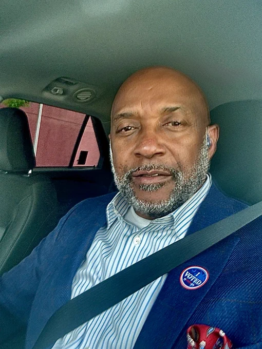 Dr. Bennie Harris smiles at the camera while wearing his “I voted” sticker.