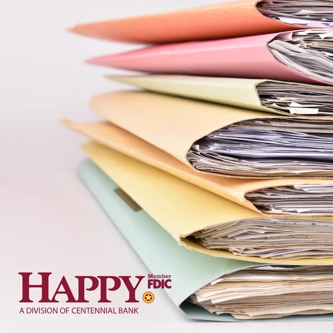 Stack of colorful folders filled with organized documents on a white surface, symbolizing efficient paperwork management.