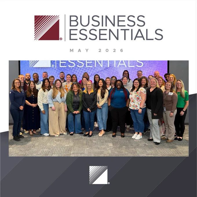 Group photo of diverse professionals attending the Business Essentials event in May 2026, standing in front of a branded backdrop.