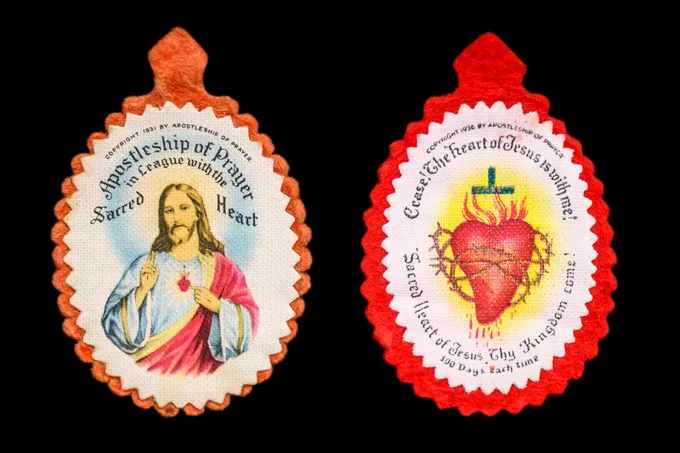 Two religious badges with scalloped edges on a black background. The left badge features an image of Jesus with a heart, surrounded by the text "Apostleship of Prayer" and "Sacred Heart." The right badge shows the Sacred Heart of Jesus with a crown of thorns, encircled by the text "Cease! The heart of Jesus is with me!" and "Sacred Heart of Jesus, Thy Kingdom Come."