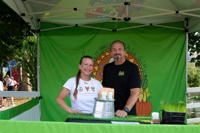 two people posing at their booth during the Iowa State Fair Farmers Market. 