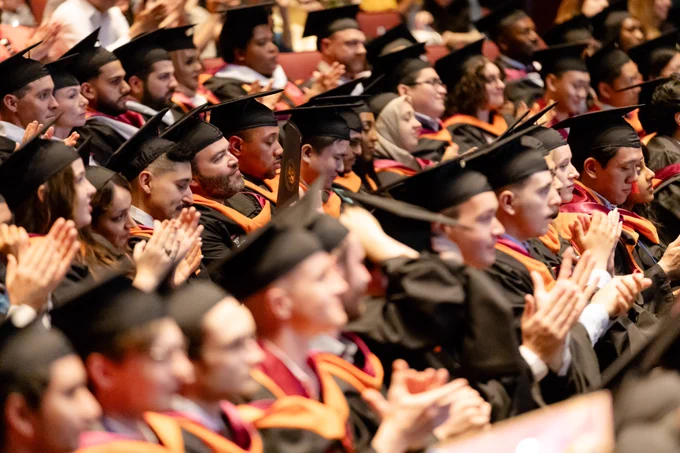 crowd shot of graduates clapping