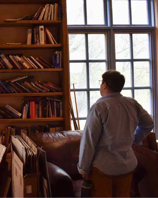 An individual looks at bookshelves filled with books inside Cormac McCarthy’s home.
