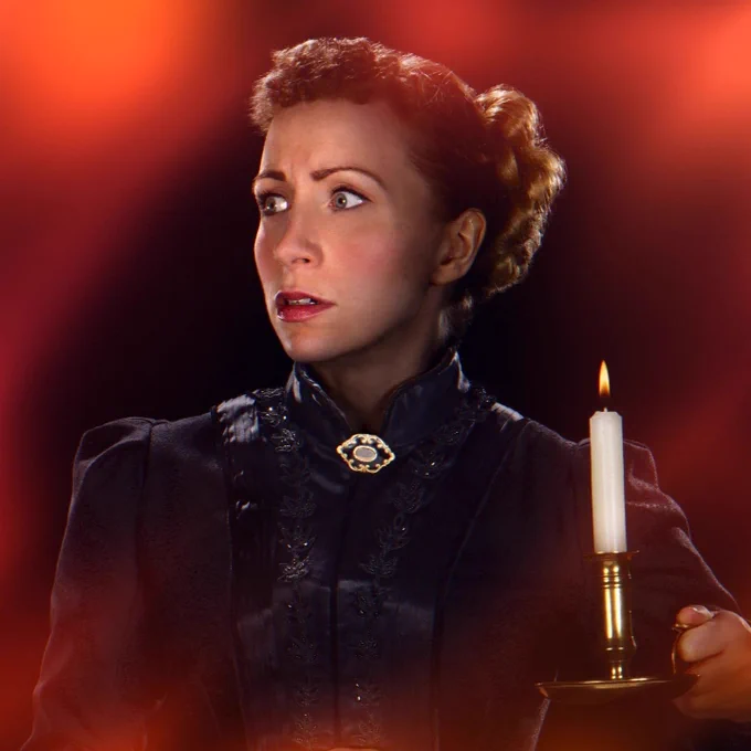 A woman wearing a Victorian dress holds a candle. Her expression looks troubled.