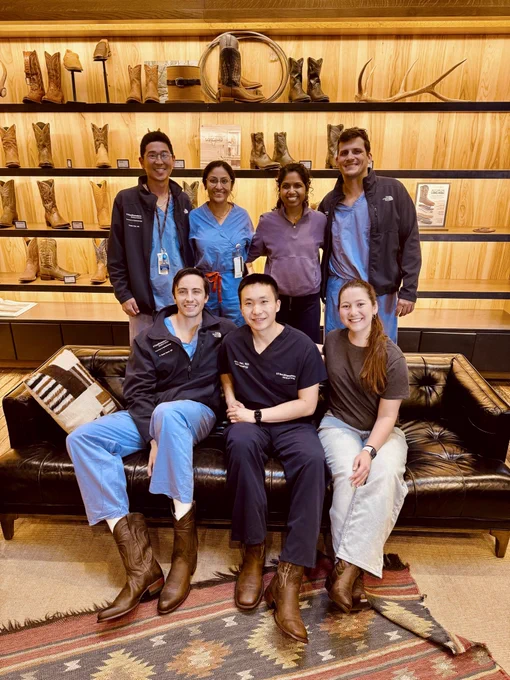 Group of 7 people in cowboy boot store smiling wearing scrubs