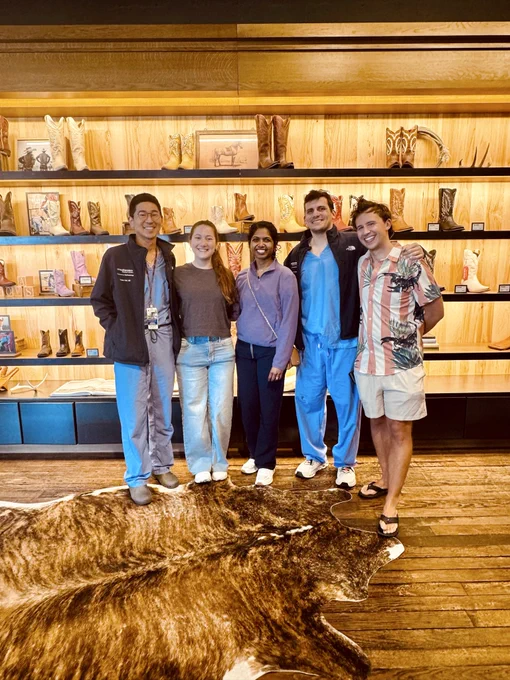 Group of 5 people in cowboy boot store smiling wearing scrubs