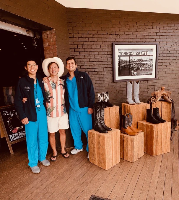 Group of 3 people in cowboy boot store smiling wearing scrubs