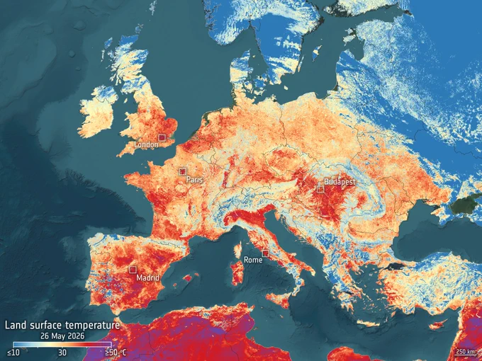 Map of Europe showing land surface temperatures on 26 May 2026, with a colour scale ranging from blue (cooler, below 10 °C) to dark red (very hot, above 50 °C). Large areas of Western and Southern Europe appear in orange and red, indicating high surface temperatures during a heatwave, particularly over Spain, France, Italy and the UK. Northern and northeastern regions, including Scandinavia and parts of Eastern Europe, are shown in lighter colours and blue, indicating cooler conditions. Major cities including London, Paris, Madrid, Rome and Budapest are marked.