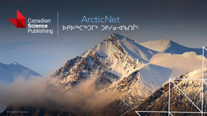 Snow-covered mountain peaks bathed in soft sunlight with mist rising around the slopes under a clear sky.