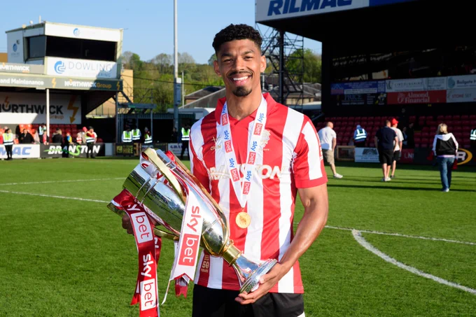 Reeco Hackett posing for a photo with the Sky Bet League One trophy.