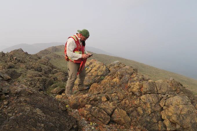 USGS researcher making observations and recording information on the outcrop of the Kanuti Ophiolite in Alaska. 