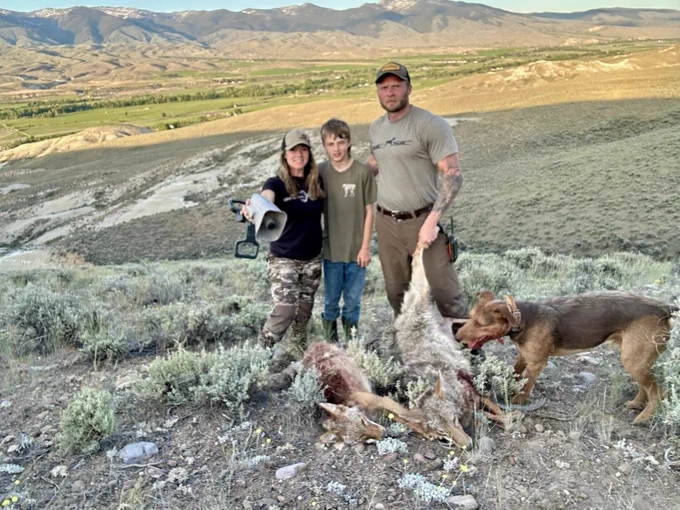 Hunters and a dog with two coyotes.