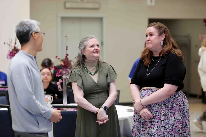 Pictured is a photo of UTA Libraries staff member Antoinette Nelson visiting with two staff members at her retirement party.