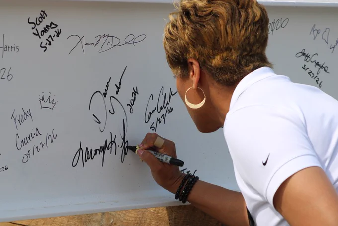 Joe T. Robinson High School Principal Laconya Isaac signs the ceremonial steel beam before it is lifted into place.