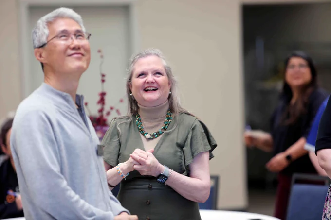 Pictured is a photo of UTA Libraries staff member Antoinette Nelson at her retirement party. In the photo, she is looking at a screen. 
