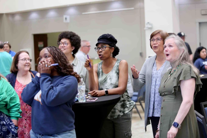 Pictured is a photo of UTA Libraries staff member Antoinette Nelson visiting with several staff members at her retirement party.