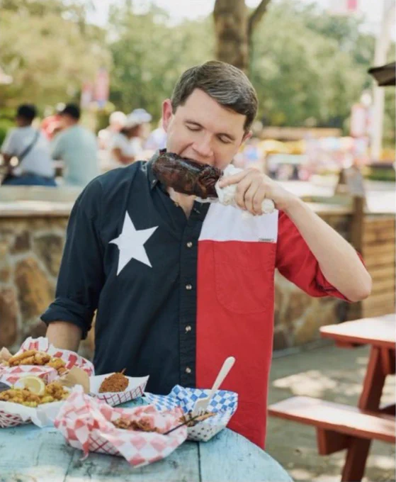 A social media graphic featuring an image of James Talarico taking a bite out of a barbecued leg. Talarico is wearing a Texas flag shirt.