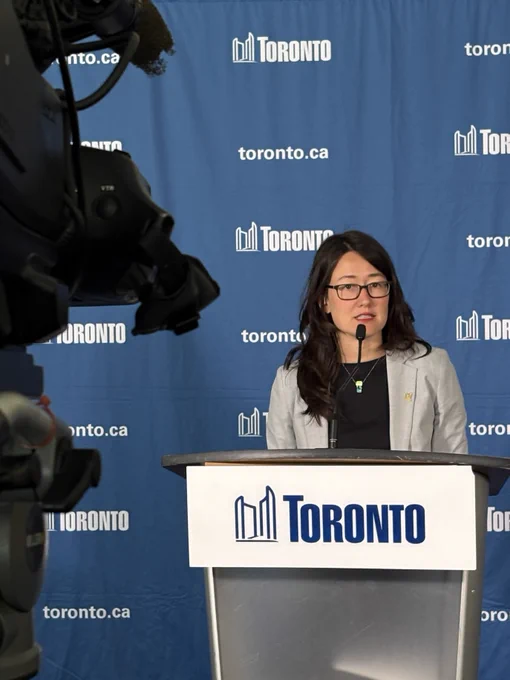 Dr. Michelle Murti, in front of a City of Toronto Podium at a press conference.