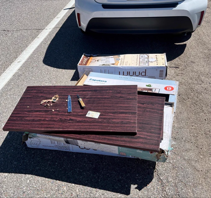 Boxes of furniture on I-70 asphalt with car at top of picture