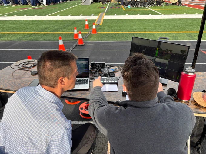 Two live broadcast producers operating video equipment during the Sandburg commencement ceremony. 