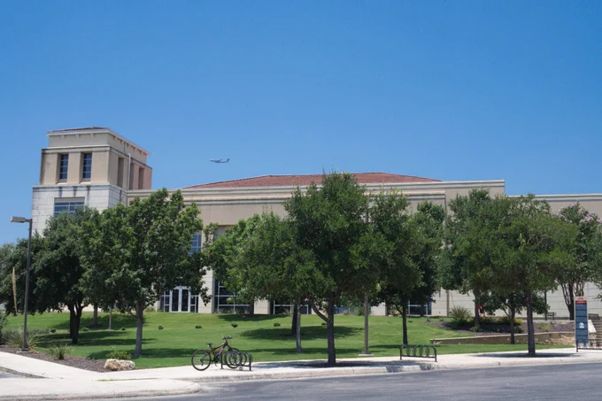Campus Recreation Center's Exterior view on a sunny day with multiple trees in front of it.