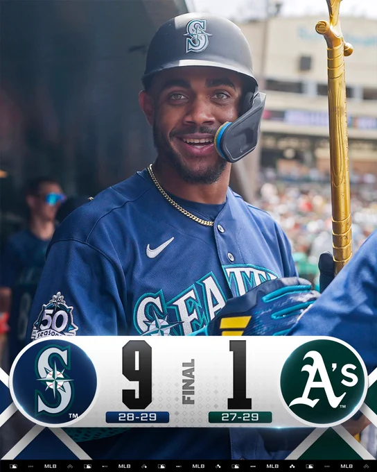 Final Score Graphic 5/27/26
Seattle Mariners 9 (28-29), Athletics 1 (27-29)
Pictured: Julio Rodríguez smiles and holds the Mariners home run trident in the dugout Wednesday afternoon. He wears a navy Seattle Mariners uniform with silver lettering and teal trim.
(Photo: Jacob Soriano/Major League Baseball)